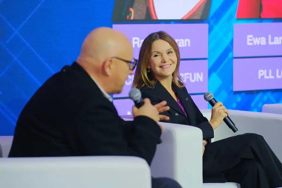 A smiling panellist with a microphone on the Executive Summit 2023 stage