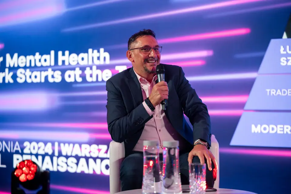 A laughing panellist with a microphone during the mental health panel, EXS 2024