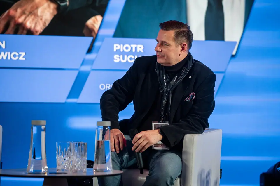 A panellist listening with a smile on the EXS 2024 stage