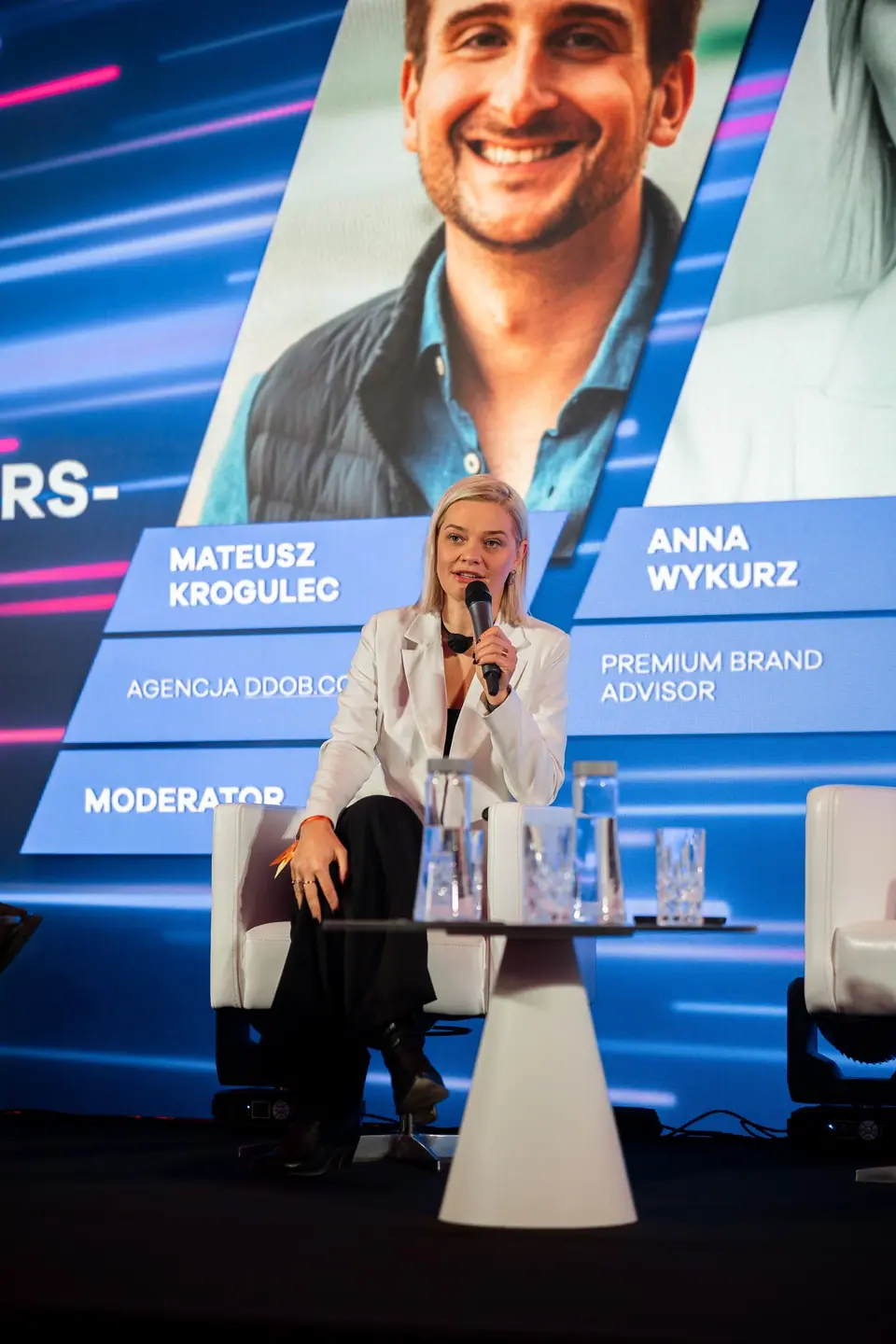 A panellist in a white blazer on the EXS 2024 stage, panel „Gen Z, Millennials, Boomers – do we still believe influencers?”